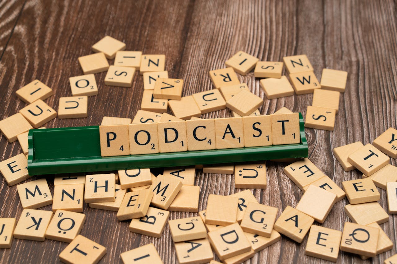 services-02 Wooden letter tiles on a board spelling the word Podcast, symbolizing digital media and creativity.